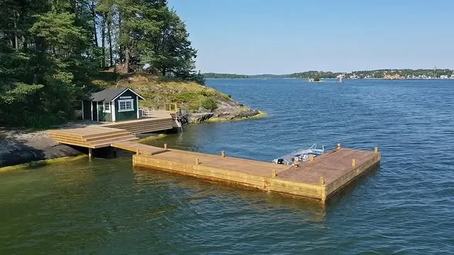 Brygga vid grön sjöbod